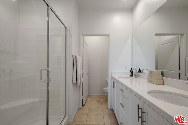 bathroom featuring tile patterned floors, toilet, walk in shower, and vanity