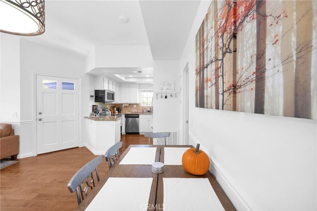 dining area with baseboards and wood finished floors