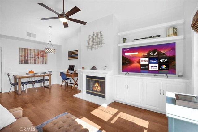 living room featuring ceiling fan and dark wood-type flooring