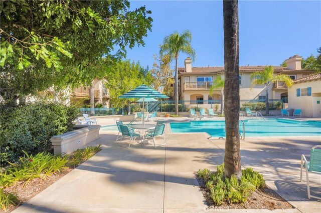 pool with a patio area and fence