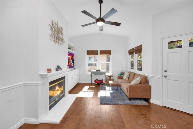 living room with hardwood / wood-style flooring, ceiling fan, and vaulted ceiling