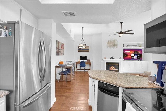 kitchen with ceiling fan, hanging light fixtures, light wood-type flooring, white cabinetry, and stainless steel appliances