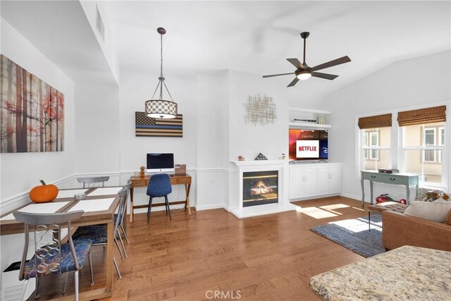 living room with hardwood / wood-style flooring, vaulted ceiling, and ceiling fan