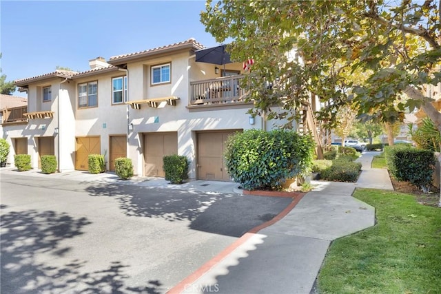 view of front of property featuring a balcony and a garage