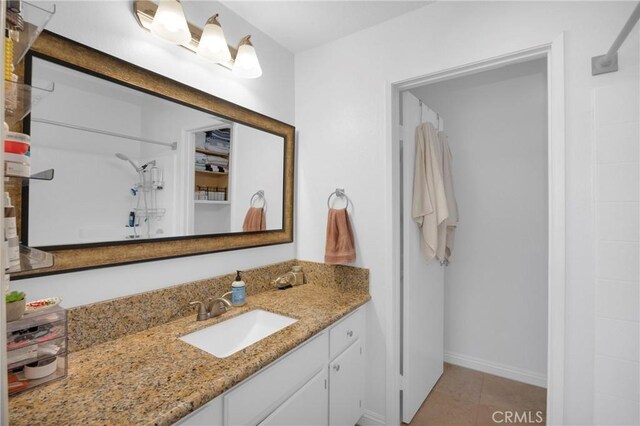 bathroom featuring tile patterned floors, walk in shower, and vanity