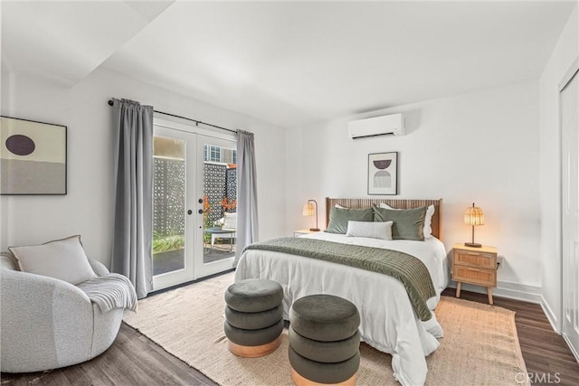 bedroom featuring dark hardwood / wood-style floors, an AC wall unit, french doors, and access to outside