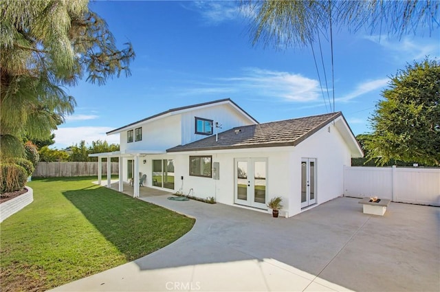 rear view of house with a patio area, french doors, and a lawn