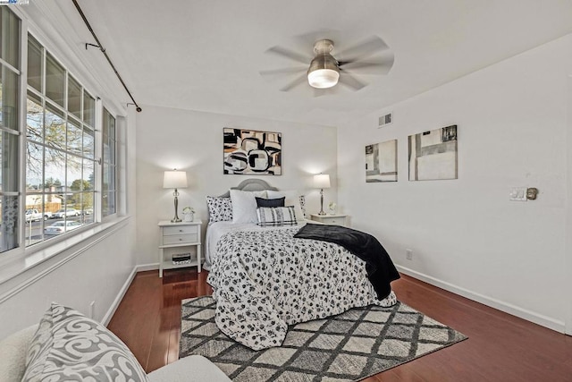 bedroom with dark hardwood / wood-style flooring and ceiling fan