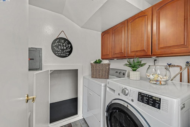 washroom featuring hardwood / wood-style flooring, cabinets, electric panel, and washer and clothes dryer