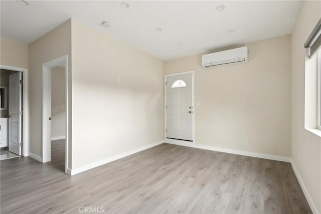 foyer with a wall mounted AC and light wood-type flooring