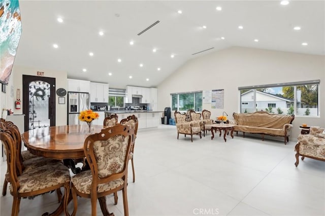 dining area with high vaulted ceiling