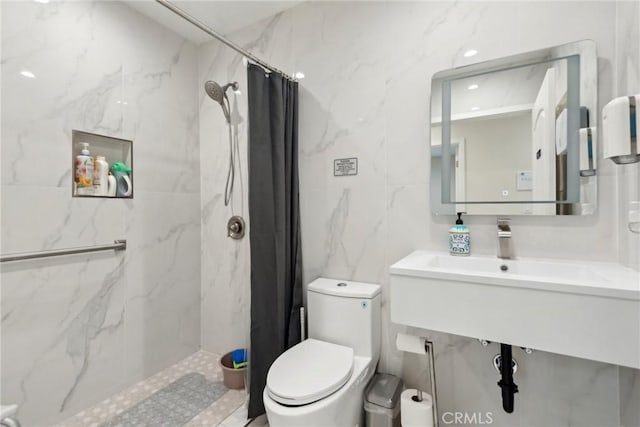 bathroom with tile walls, curtained shower, and toilet