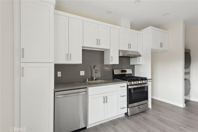 kitchen with white cabinetry, appliances with stainless steel finishes, sink, and light wood-type flooring