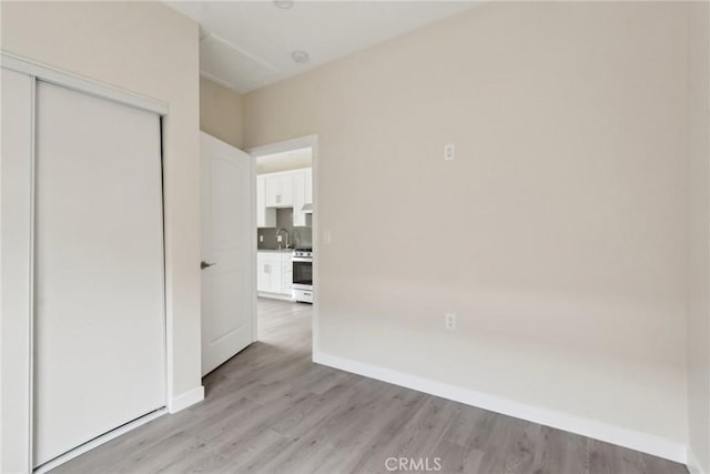 unfurnished bedroom with a closet and light hardwood / wood-style flooring