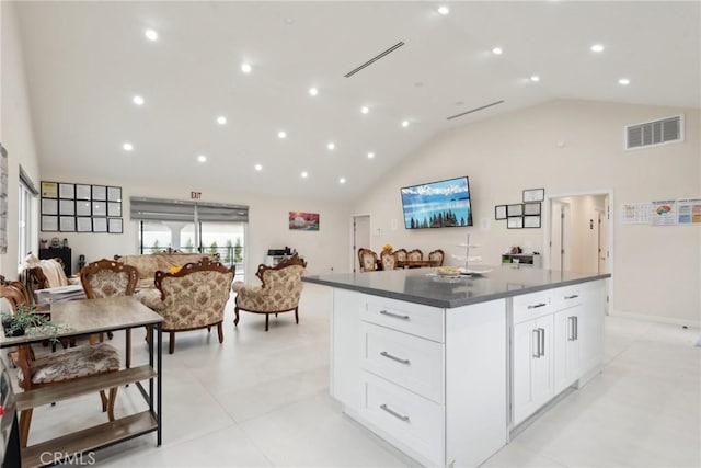 kitchen with white cabinetry, a center island, and high vaulted ceiling