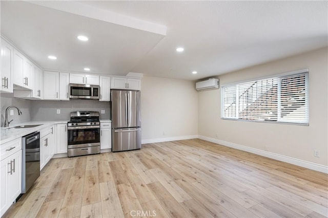 kitchen with white cabinets, light wood-type flooring, appliances with stainless steel finishes, and sink