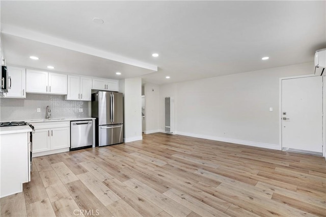 kitchen with white cabinets, light wood-type flooring, appliances with stainless steel finishes, and sink