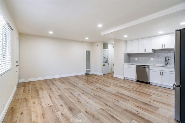 kitchen featuring backsplash, sink, stainless steel appliances, and white cabinetry