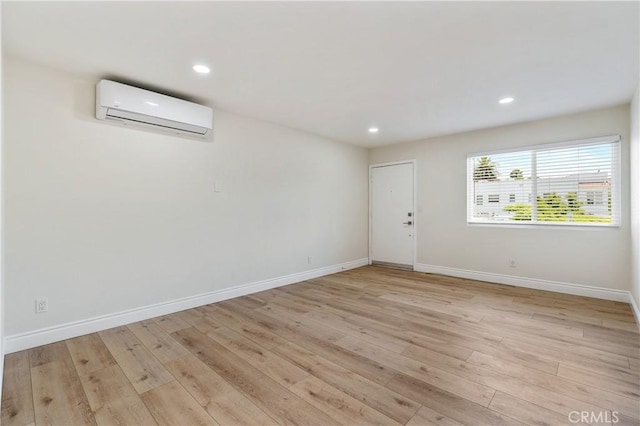 empty room with light hardwood / wood-style floors and a wall mounted AC