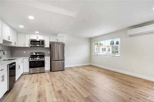 kitchen featuring sink, white cabinets, appliances with stainless steel finishes, and a wall mounted air conditioner