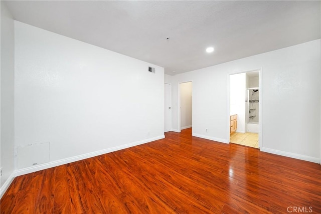 unfurnished bedroom with connected bathroom and light hardwood / wood-style flooring