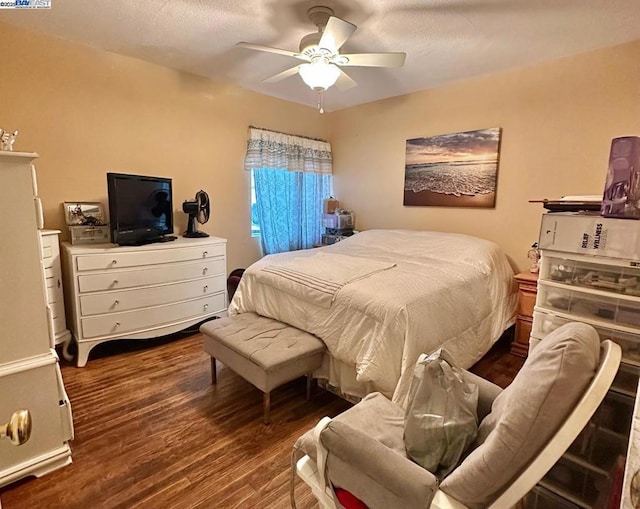 bedroom featuring a textured ceiling, dark wood-type flooring, and ceiling fan