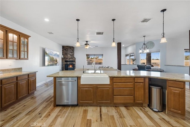 kitchen with ceiling fan with notable chandelier, pendant lighting, dishwasher, light hardwood / wood-style floors, and sink