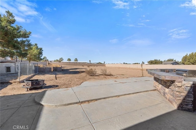 view of yard featuring an outdoor kitchen and a patio