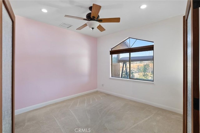 carpeted spare room with ceiling fan