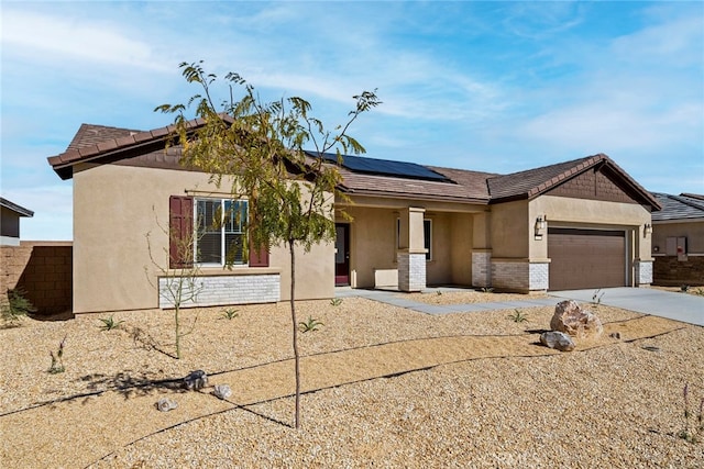 view of front facade featuring a garage and solar panels