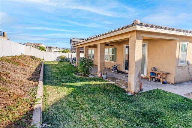 rear view of property featuring a lawn and a patio