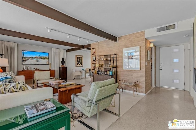 living room featuring beamed ceiling and wooden walls