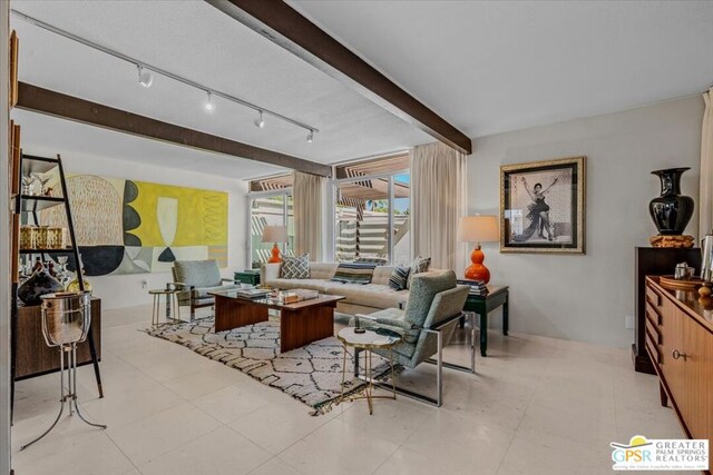 tiled living room featuring rail lighting and beamed ceiling