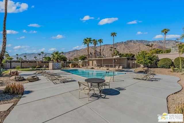 view of pool with a mountain view and a patio