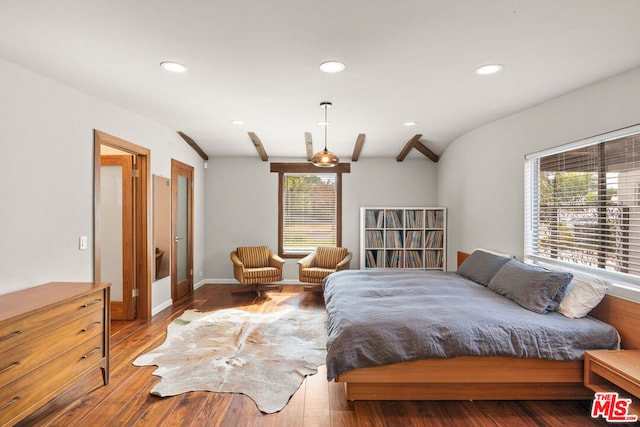 bedroom featuring lofted ceiling with beams, multiple windows, and hardwood / wood-style floors