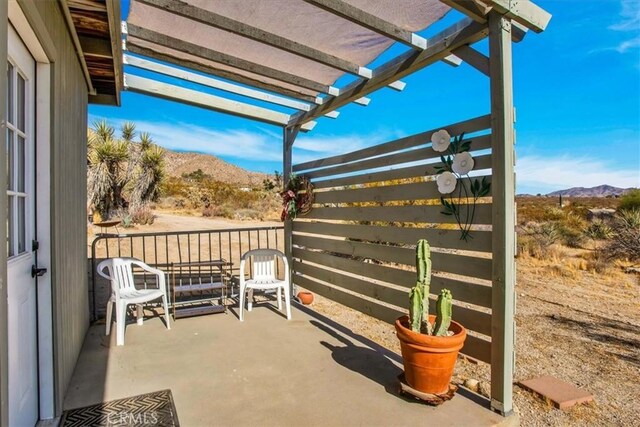 view of patio / terrace with a pergola and a mountain view