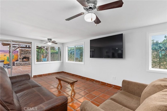 living room with ceiling fan, a fireplace, and tile patterned floors