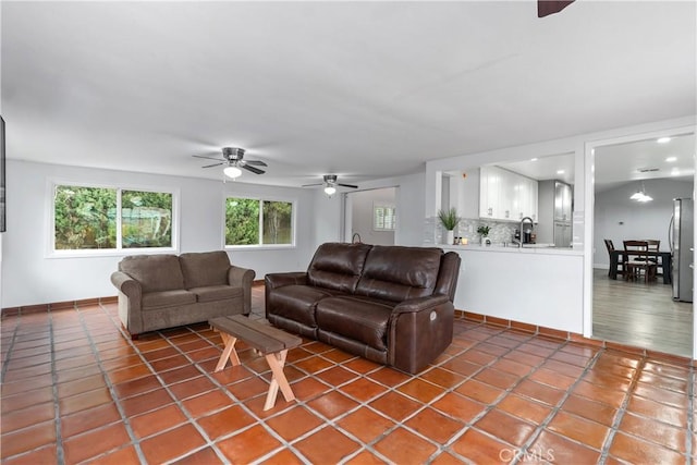 tiled living room with ceiling fan and sink