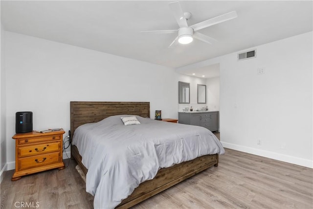 bedroom featuring ceiling fan, ensuite bathroom, and light hardwood / wood-style floors