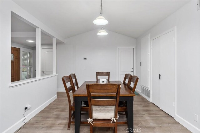 dining space featuring vaulted ceiling and hardwood / wood-style flooring