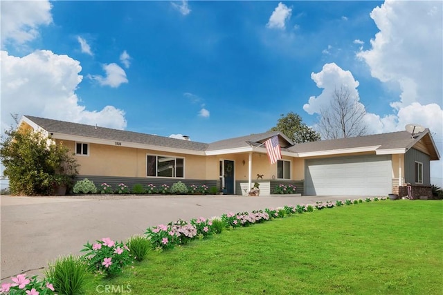 ranch-style home with a front yard and a garage