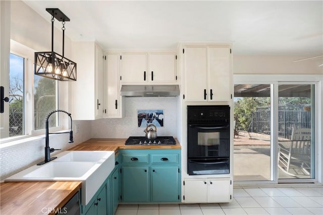 kitchen with butcher block countertops, oven, a warming drawer, a sink, and exhaust hood