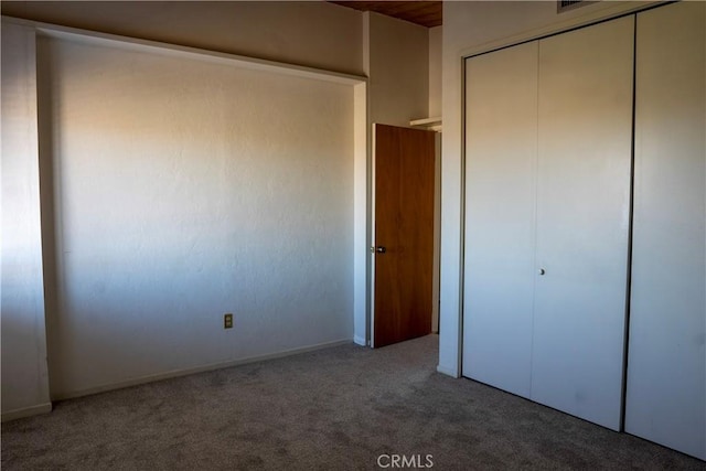 unfurnished bedroom featuring carpet and a closet