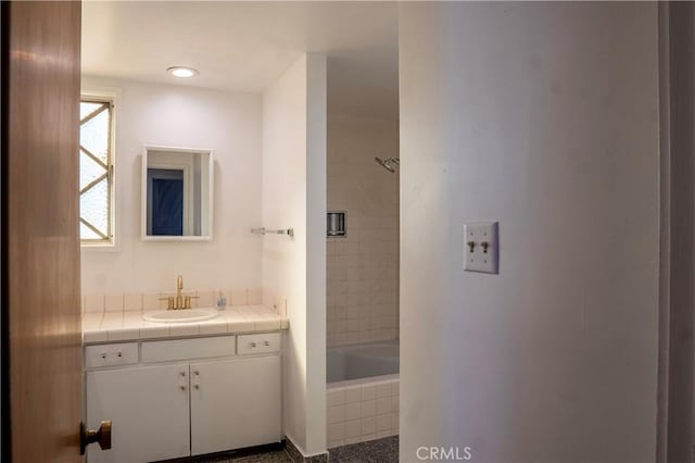 bathroom with vanity and tiled shower / bath combo