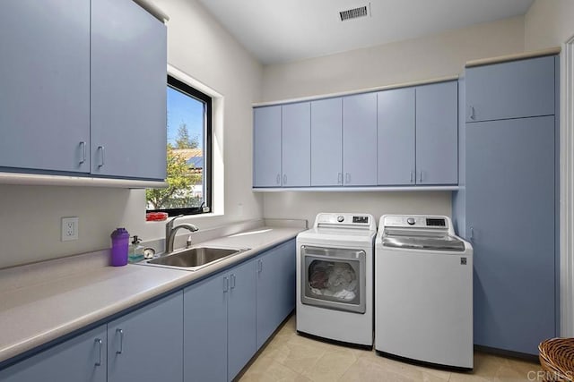 laundry area with cabinets, sink, light tile patterned floors, and washing machine and dryer