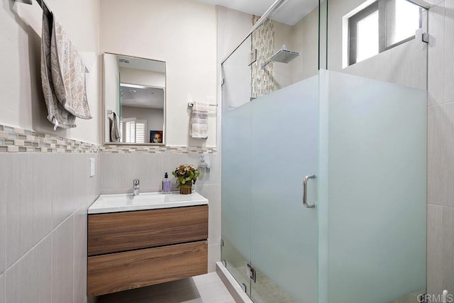 bathroom with tile walls, walk in shower, and vanity