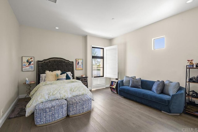 bedroom with multiple windows and hardwood / wood-style floors