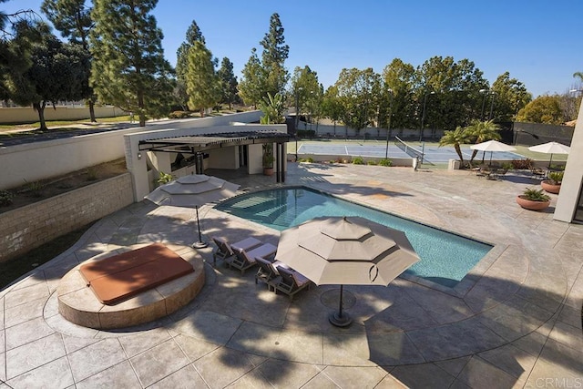 view of swimming pool featuring tennis court and a patio