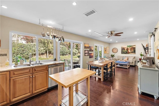 kitchen featuring dishwasher, sink, dark hardwood / wood-style floors, ceiling fan, and light stone counters