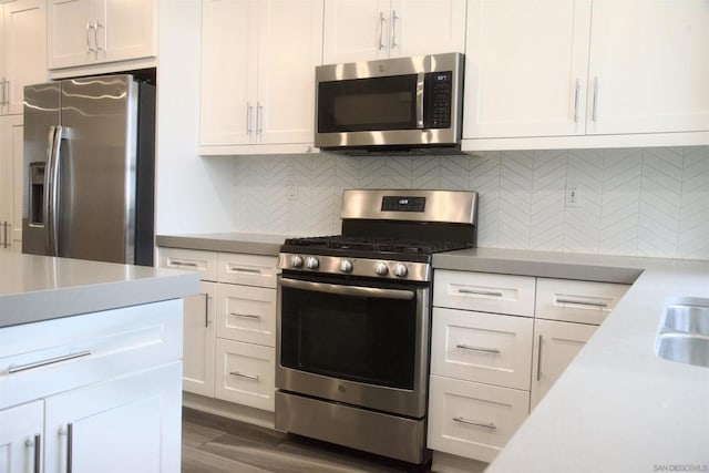 kitchen featuring white cabinets, decorative backsplash, dark hardwood / wood-style floors, and stainless steel appliances